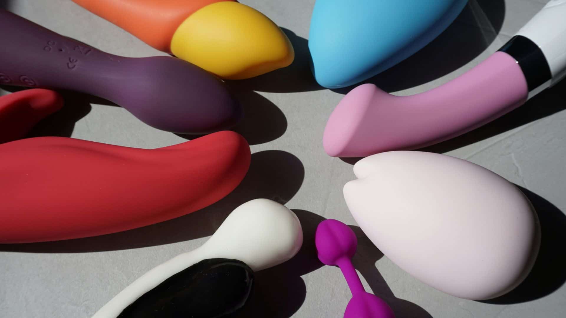 Pleasure Malta – Sex shop Malta Silicone sex toys in various shapes and colors arranged on a neutral surface, highlighting body positivity and sexual wellness.