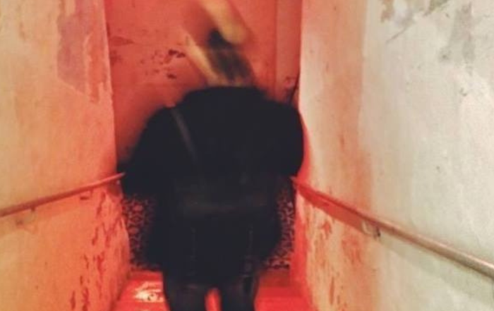 Matthew going down a staircase. Photo shows movement and is blurry with red light in the background.