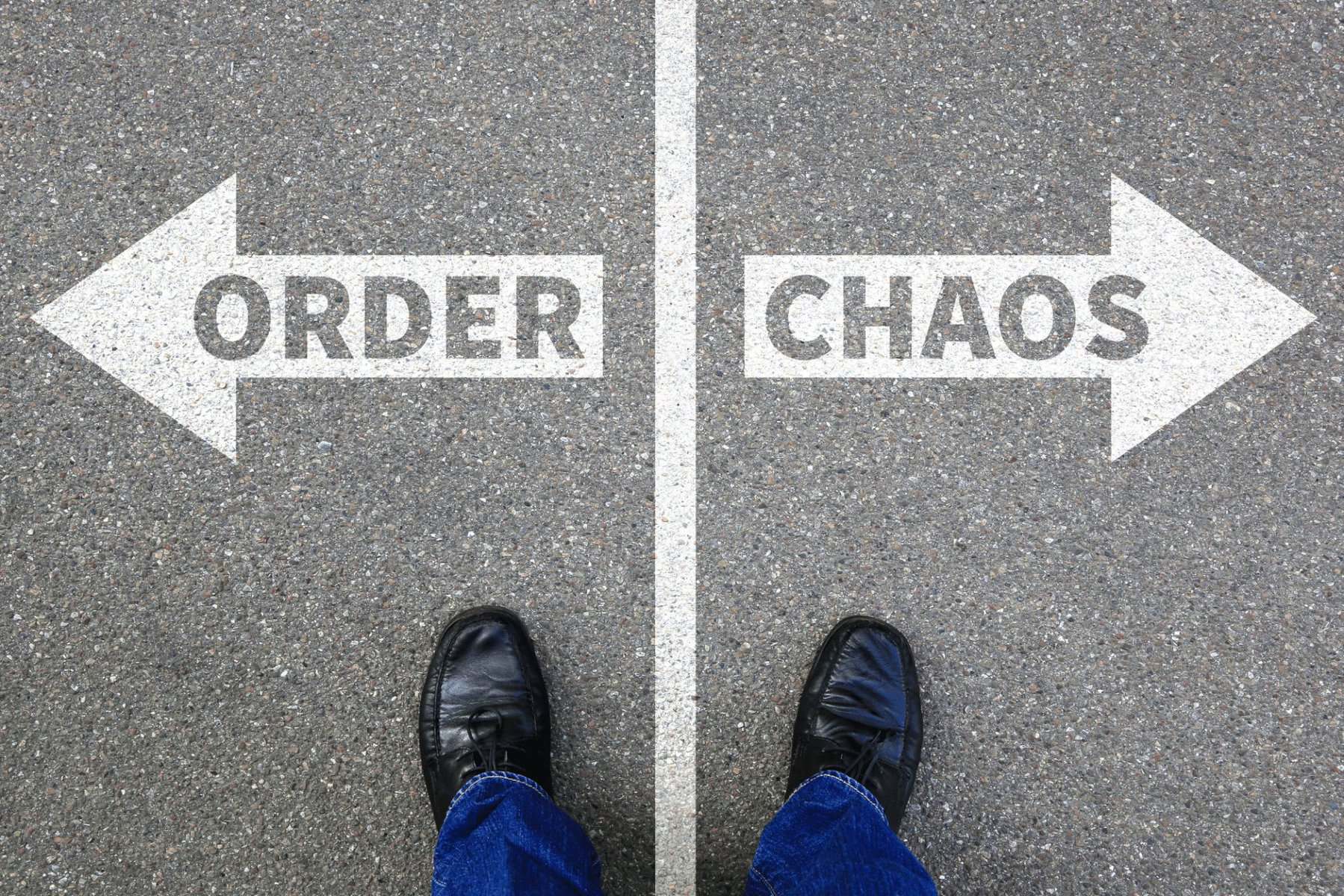 Order instead of chaos concept as a person stands at a crossroads on a street with arrows pointing in opposite directions labeled "Order" and "Chaos".