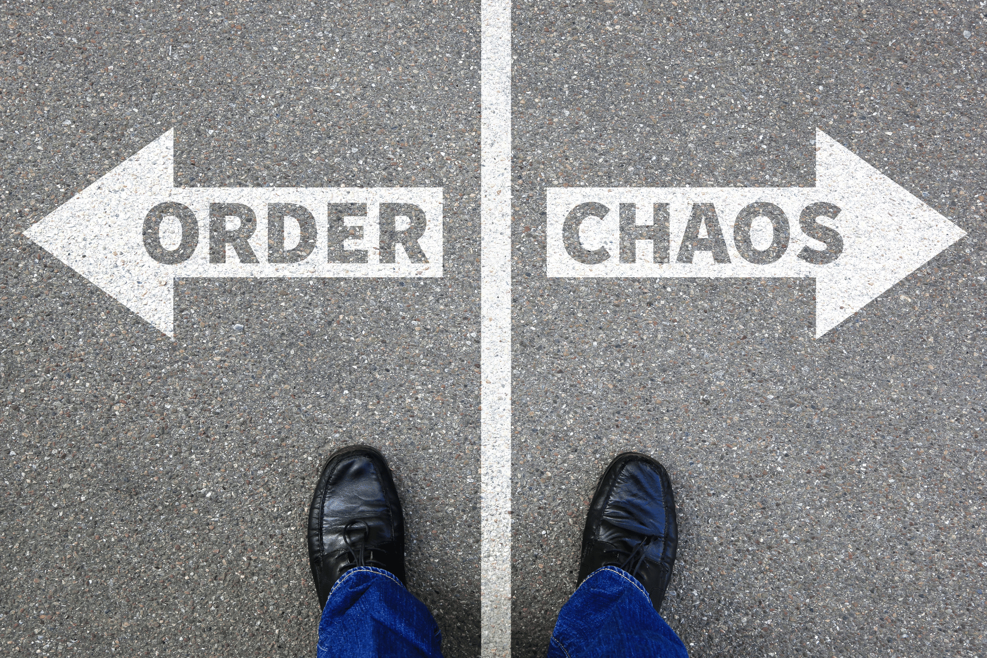 A photo of a tarmac road with a white line in the middle. on the right hand side there's written "order" the other side there's written "Chaos"