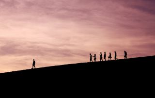 Helpfulness and personal growth often occur through gradual progress and support from others; this image depicts a silhouette of individuals walking up a hill, symbolizing journey towards self-improvement and resilience.