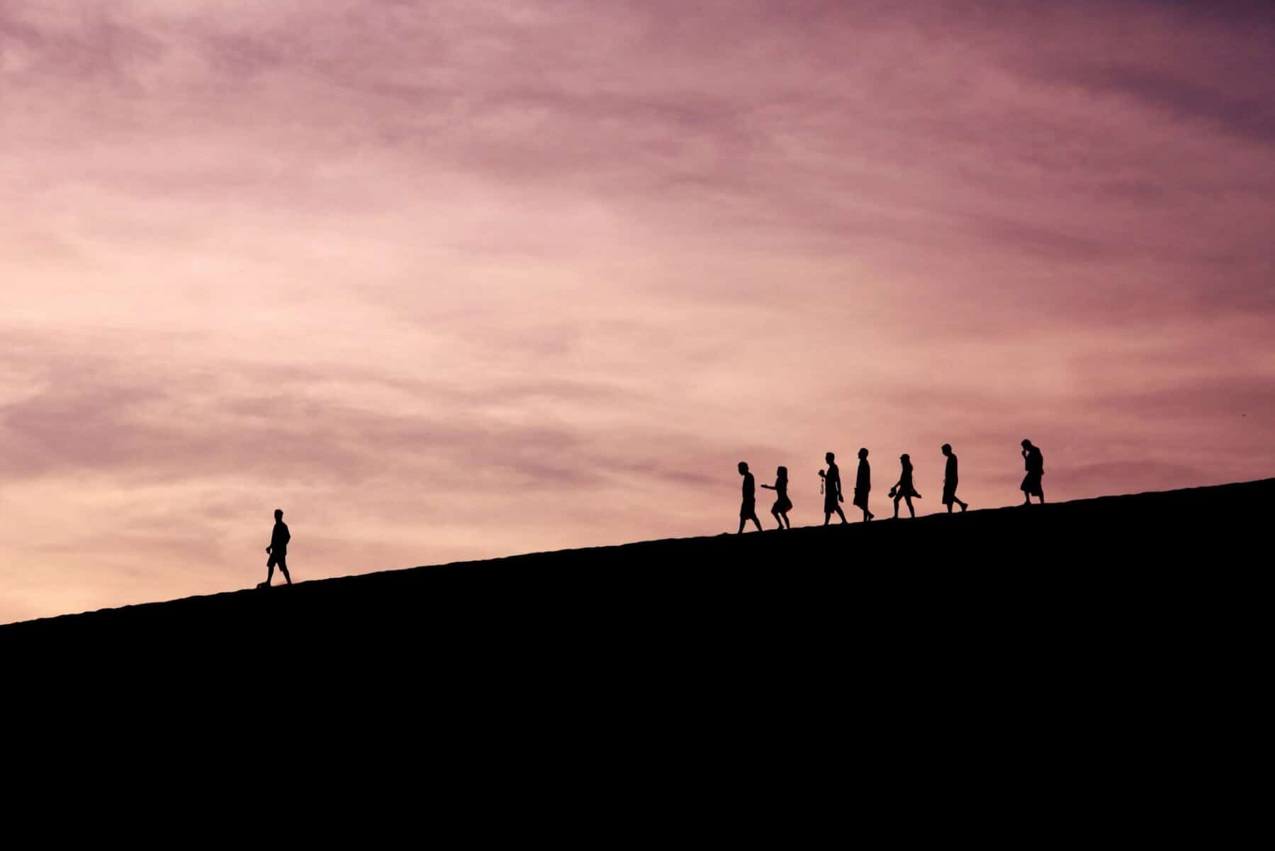 Helpfulness and personal growth often occur through gradual progress and support from others; this image depicts a silhouette of individuals walking up a hill, symbolizing journey towards self-improvement and resilience.