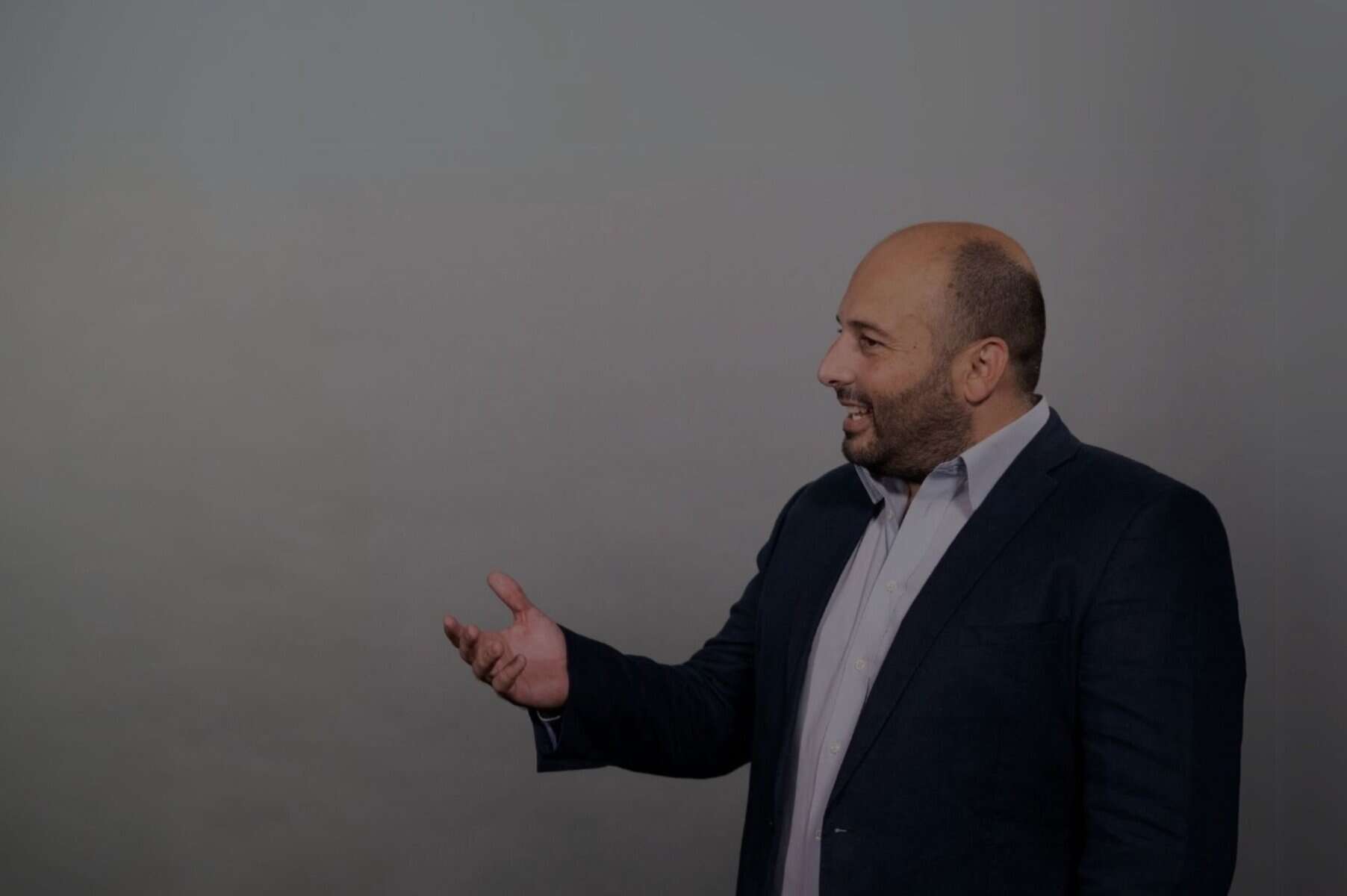 Insightful man engaging in a conversation or presentation, emphasizing communication and emotional expression, highlighting skills in interpersonal connection and professional interaction.