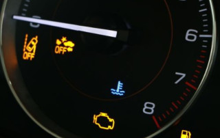 Low tire pressure warning with multiple dashboard indicator lights illuminated, including check engine and oil warning signals on a car instrument panel.