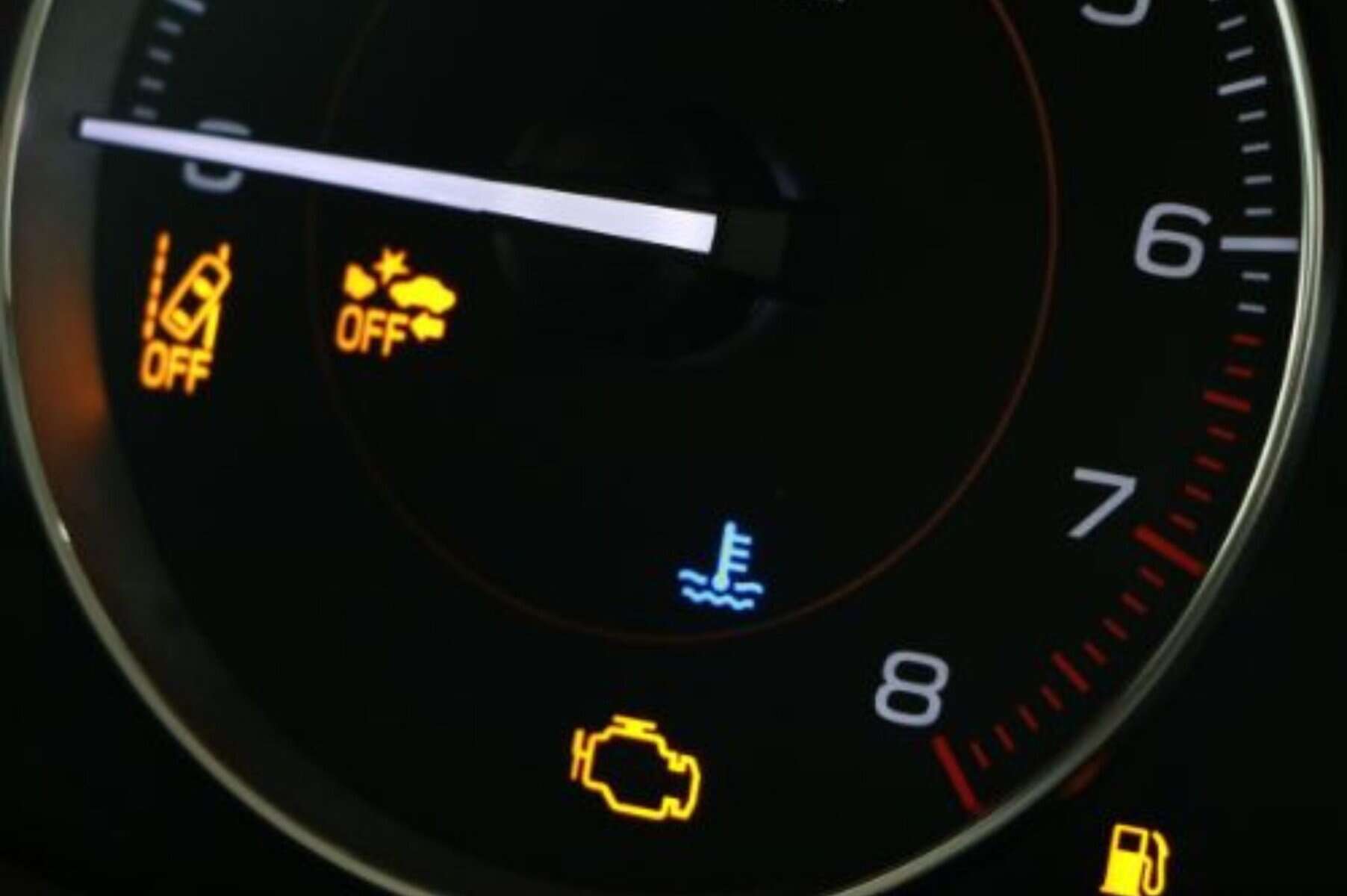 Low tire pressure warning with multiple dashboard indicator lights illuminated, including check engine and oil warning signals on a car instrument panel.