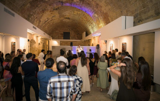 Engaged audience at a mental health awareness event in a historic venue with a speaker on stage.