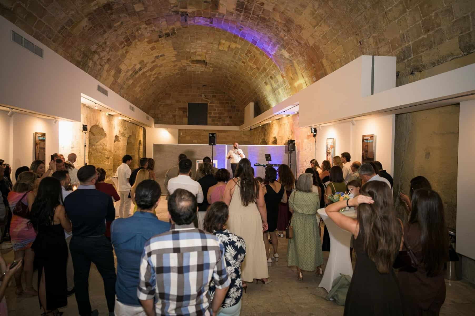 Engaged audience at a mental health awareness event in a historic venue with a speaker on stage.